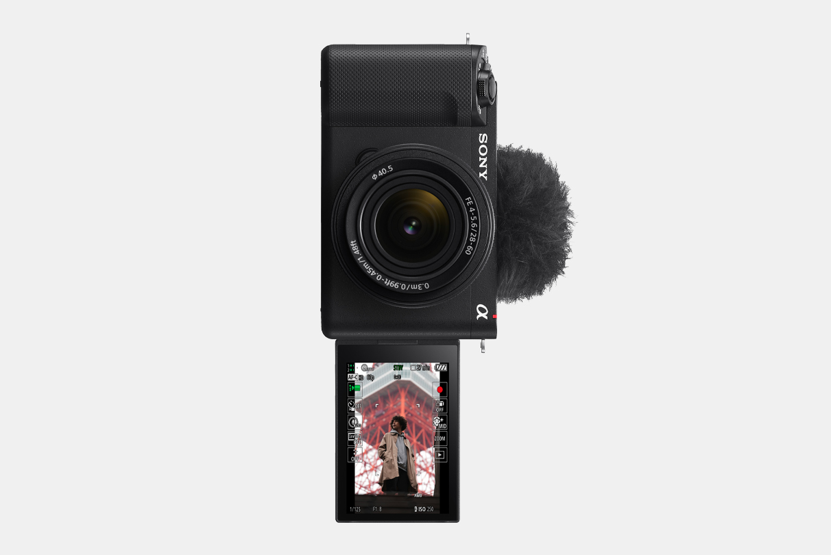 Slika fotoaparata ZV-E1 z LCD-zaslonom, obrnjenim naprej, s sliko človeka, prikazanega na navpičnem informacijskem zaslonu