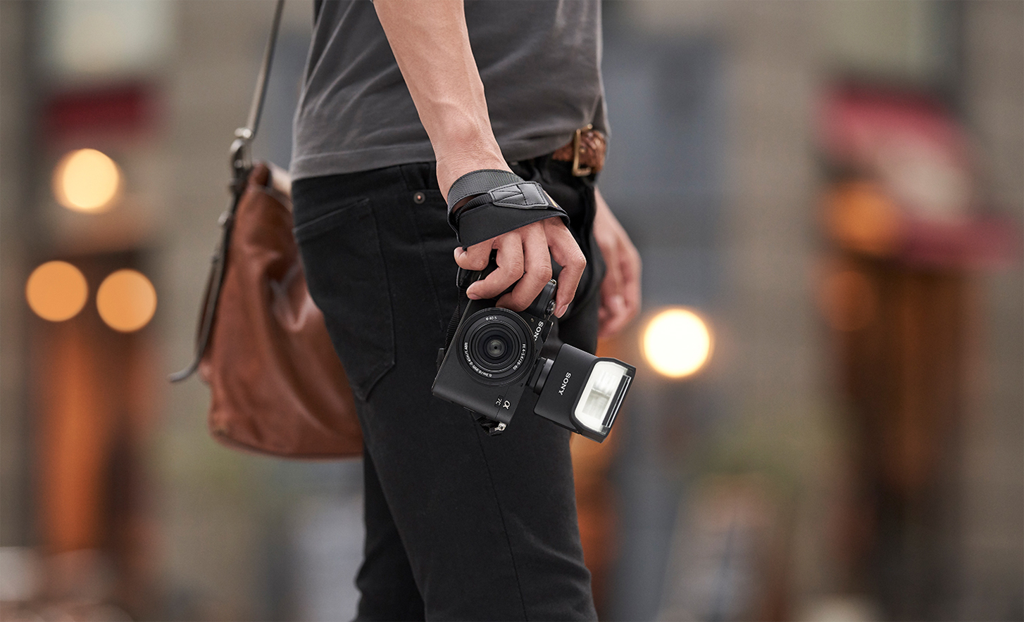 Slika uporabe, kjer oseba drži fotoaparat z nameščeno bliskavico